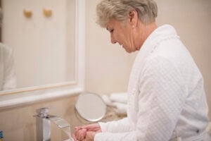 Older woman washing her hands at home as part of her daily personal care routine